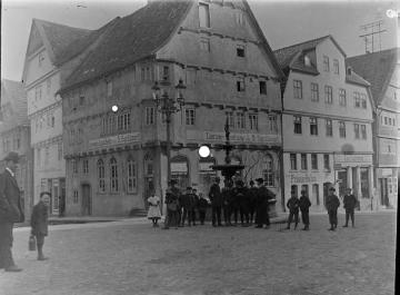 Richard Schirrmann, Wanderungen: Männerwandergruppe mit Gitarre an einem Marktbrunnen (Original ohne Angaben), undatiert, um 1912?