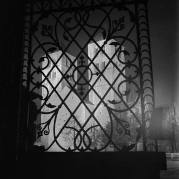 Blick durch die Gitter des Bischöflichen Palais auf die angestrahlte Westfassade des Paulus-Domes