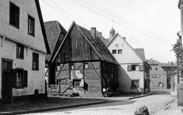 Dorfstraße mit Restaurant Heinrich Bleiming (Hintergrund), links davor ein Friseursalon, um 1920?