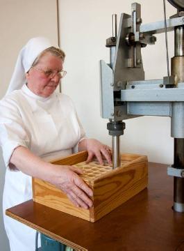 Maschinelle Hostienbäckerei im Mutterhaus der Franziskanerinnen von der ewigen Anbetung zu Olpe: Schwester Gerlinde an der Oblatenstanze