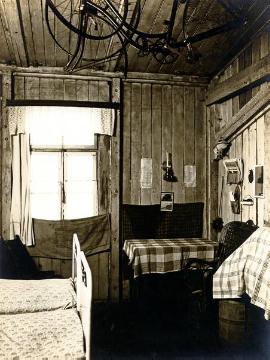 Beengter Wohn-Schlaf-Raum in einer Holzbaracke, Ort unbekannt, undatiert, 1920er Jahre