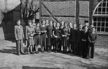Konfirmation in Nottuln, 1949: Konfirmandengruppe mit Pfarrer Ernst Stümke vor dem Gemeindezentrum der evangelischen Kirche. Vierte von links: Renate Weber, Tochter des Fotografen Johannes Weber.