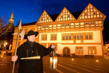 "Der Nachtwächter von Blomberg" - Stadtführer Werner Kuloge mit Hellebarde, Horn und Laterne vor dem abendlich beleuchteten Rathaus