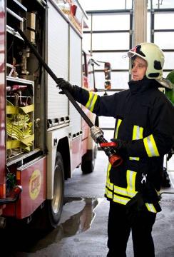 Feuerwehr-Hauptwache Gelsenkirchen: Feuerwehrmann bei der Wartung eines Löschwagens (Zentrale Feuer- und Rettungswache 2 in Buer, Seestraße 3)