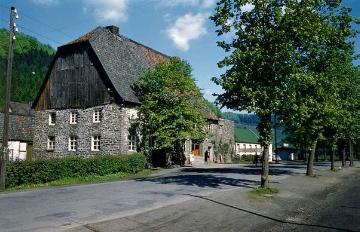 Bruchsteinhaus mit Brettergiebel und Walmdach bei Holmecke