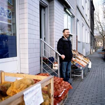 Ladeninhaber vor seinem Lebensmittelmarkt "Tugra Kultur Merkezi“ im Gemeinde- und Moscheegebäude "Tugra Kultur Zentrum", Gelsenkirchen-Bulmke-Hüllen, Kesselstraße 25-27
