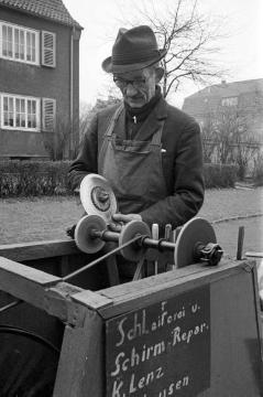 Fahrender Handwerker K. Lenz mit mobiler Werkbank für Schleiferei und Schirmreparaturen. Castrop-Rauxel, um 1962/1964.