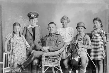 Familienporträt, unbezeichnet - Atelierfotografie von Ernst Jäger, Harsewinkel. Auf dem Schauckelpferd: sein einziger Sohn Hermann (1930-1953). Undatiert, um 1940.