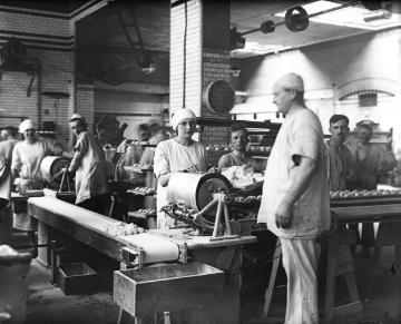 Brotfabrik: Brötchenherstellung: Bäckerinnen an der Teigwirkmaschine