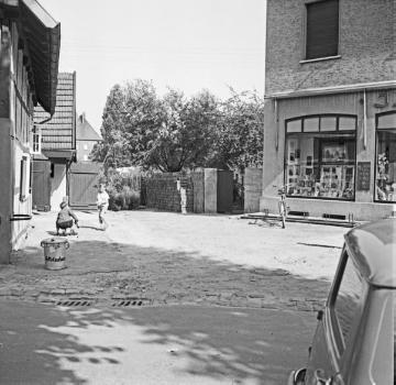 Harsewinkel, 1955: Partie am St. Lucia-Kirchplatz - rechts angeschnitten: Haus Ernst Jäger mit Fotoatelier und Ladengeschäft für Haushalts- und Geschenkartikel am Kirchplatz 179.