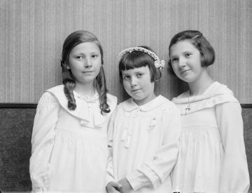 Kommunionkind Irene Jäger (*um 1928) porträtiert um 1936 mit ihren Schwestern Agnes (links) und Margret - Töchter des Fotografen Ernst Jäger und Ehefrau Agnes. Atelier Jäger, Harsewinkel, undatiert.