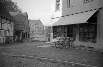 Harsewinkel 1946/1950: Fotogeschäft Ernst Jäger (rechts) am St. Lucia-Kirchplatz mit Blick auf die Schule (Bildmitte).