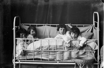 "Schlafengehen" im Fotoatelier Jäger, Harsewinkel, um 1933: Margret, Agnes, Irene und Hermann (rechts, *1930), Kinder des Fotografen Ernst Jäger und Ehefrau Agnes.