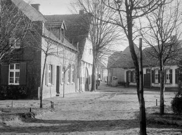 Harsewinkel, Brockhägerstraße (unbefestigt) Höhe Kirchplatz: Küsterei und Haus Lanwehr (links). Undatiert, um 1920?