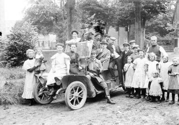 Ein neues Automobil am Kirchplatz in Harsewinkel, 1911 - mit Kranz: Fotograf Ernst Jäger, auf der Motorhaube: seine Halbschwestern Änne und Maria-Elisabeth Jäger.