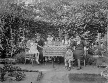 In der Gartenwirtschaft Johannsmann, Harsewinkel, um 1933: Agnes Jäger (rechts), Ehefrau des Harsewinkeler Fotografen Ernst Jäger, mit ihren drei Töchtern und Sohn Hermann (vorn) - Dame links und Mädchen mit Zöpfen nicht bekannt.