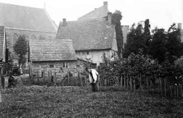 Landwirt Hülsewedde (genannt "Pottbäcker") in seinem Garten an der St. Lucia-Kirche, Harsewinkel. Undatiert, um 1920?