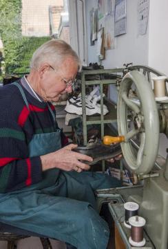 Der achtzigjährige Hubert Poerschke, Orthopädischer Schuhmachermeister in Brochterbeck, bei der Schuhreparatur. Ein Besuch in seiner Werkstatt an der Dörenther Straße 13 im April 2015.