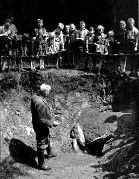 Schulklasse mit dem Archäologen Otto Krasa an der Fundstätte eines keltischen Eisenschmelzofens ("Rennofen", 500 v. Chr.)