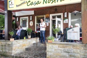 Gastronomie in Brochterbeck: Restaurant und Eisdiele "Casa Nostra" am Mühlenteich - stehend: Inhaber Shemsi Limani, zugewandert aus Kroatien.
