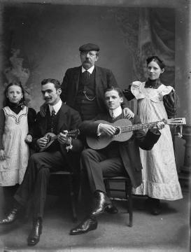 Fotograf Johann Hermann Jäger (1845-1920) mit seinen Töchtern Gertrud (links) und Maria-Elisabeth (Lilli). Vorn: Freunde seines Sohnes Ernst. Atelier Jäger, Harsewinkel, um 1907.