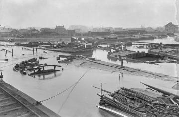 Erster Weltkrieg [Original ohne Angaben, undatiert]: Zerstörte Frachtschiffe in einer Hafenanlage an einem Fluss oder Kanal