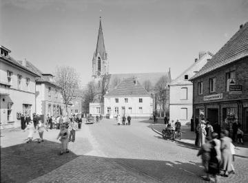 Harsewinkel - Alter Markt Richtung Münsterstraße und St. Lucia-Kirche. Links: Gasthof und Hirsch-Apotheke, rechts: Drogerie Eduard Hentschel. Undatiert, um 1960?