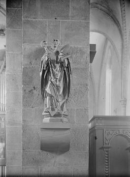 Ev. Pfarrkirche Enger, ehemalige Stiftskirche St. Dionysius: Säulenskulptur des Kirchenpatrons Dionysius am linken Vierungspfeiler. Undatiert.