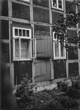 Fachwerkfassade mit zweigeteilter Haustür ("Klöndör") und Hausinschrift. Ravensberger Land, vermutlich Enger. Undatiert, 1940er Jahre?