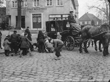 Timpkenfest am Dreikönigstag, Enger - Kinder beim Aufsammeln von geworfenen Münzen. Undatiert.