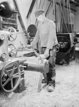 Holzschuhmanufaktur: Arbeiter beim Schlichten von Rohlingen mit dem Pfahlmesser