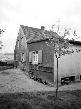 Schlichtwohnhaus am Rande einer Neubausiedlung in Hamm - rechts: Anbau mit zwei Feuerstellen (?) unter dem Hausboden. Standort unbekannt, undatiert.