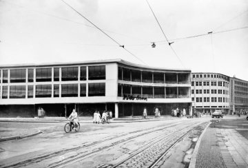 Hamm - Bahnhofstraße mit dem Rohbau des Kaufhauses Müller-Hamm. Undatiert, um 1951/1952. [Anmerkung: Fußgänger vor der Erdgeschossfront sind einmontiert].