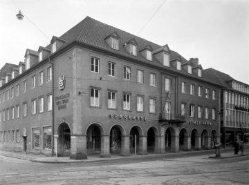 Sparkasse Hamm, Hauptgeschäftsstelle Marktplatz Ecke Martin-Luther-Straße - erbaut 1950/1951 im Stil des alten Rathauses (zerstört durch Bombeneinschlag 1944). Anschnitt rechts: Modehaus Rosenberger. Undatiert, um 1957.
