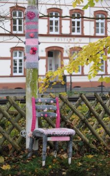 Straßenbildverschönerung in Fröndenberg: "Bestrickter Stuhl an bestrickter Laterne" - eine künstlerische Initiative der Anwohner der Wilhelm-Feuerhake-Straße - im Hintergrund das Postamt. November 2017.