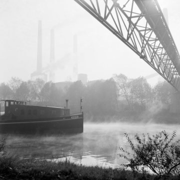 Schiff auf dem Rhein-Herne-Kanal; im Hintergrund die rauchenden Schlote der Kokerei Graf Bismarck