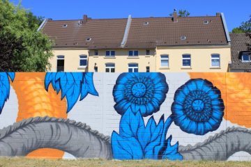 Fassadenmalerei in Herne: Wandgemälde an einer Grundstücksmauer in der "Straße des Bohrhammers", 2018.