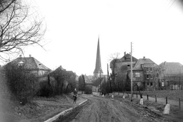 Delbrück-Ortsrand um 1952: Graf-Sporck-Straße (unbefestigt) Richtung Alter Markt. Bildmitte: Kirchturm von St. Johannes Baptist, links Haus Köller, rechts Häuser Eblenkamp und Westerhorstmann.