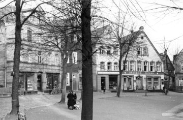 Delbrück-Kirchplatz um 1952: Porzellanwarengeschäft und Drogerie Peters im Kirchenrundling an der St. Johannes Baptist-Kirche (Nordseite).