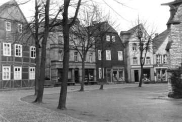Delbrück-Kirchplatz um 1952: Geschäftshäuser im Kirchenrundling an der St. Johannes Baptist-Kirche (Ostseite).