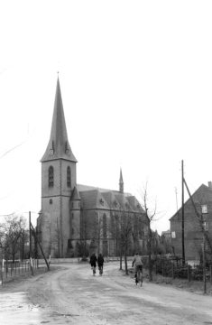 Delbrück-Westenholz: Dorfzentrum mit Westholzer Straße und kath. Pfarrkirche St. Josef, erbaut 1901 im neugotischen Stil. Ansicht von Südwesten um 1952.