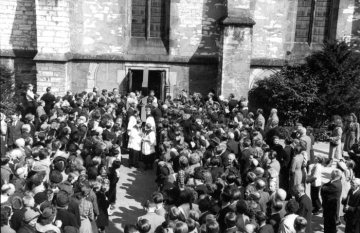 Delbrück zu Ostern, um 1952: Versammlung der Gemeinde zur "Delbrücker Kreuztracht", Karfreitagsprozession von der St. Johannes Baptist-Kirche zur Kreuzkappelle an der Ostenländer Straße.