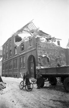 Kriegsschäden in Hamm 1940-1944: Zerstörtes Gebäude mit vergitterten Erdgeschossfenstern und großer Toreinfahrt. Standort unbezeichnet. Undatiert, um 1946 [?]