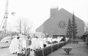 St. Bonifatius-Kirche, Hamm: Geistliche mit Pfarrer (hinten Mitte im Festornat) auf dem Weg zur Messe. Undatiert, 1970er Jahre [?]