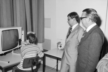 Besuch im Sonderschulzentrum Münster-Kinderhaus: Städtebauminister Christoph Zöpel (Mitte) und Landesdirektor Neseker (rechts) mit einem Schüler vor einem Fernseher