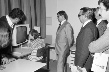 Besuch im Sonderschulzentrum Münster-Kinderhaus: Städtebauminister Christoph Zöpel (Mitte) und Landesdirektor Neseker (rechts) mit einem Schüler vor einem Fernseher.