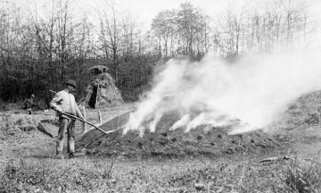 Köhler beim Abdecken des brennenden Holzkohlenmeilers (Siegerland)