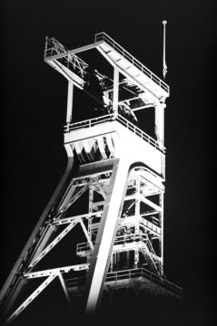 Wahrzeichen der Stadt Castrop-Rauxel: Förderturm/Schacht 7 der Zeche Erin (stillgelegt 1983), nachts illuminiert durch das Lichtkunstwerk "Nacht-Tag-Panorama". Ansicht im Dezember 1995.