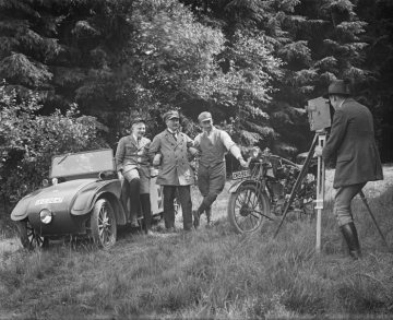 Motorisierung in der Weimarer Republik: Zwei Autofahrer und ein Motorradfahrer werden von einem Kameramann gefilmt. Fotografie aus der historischen Bildsammlung Klein-Happe, undatiert