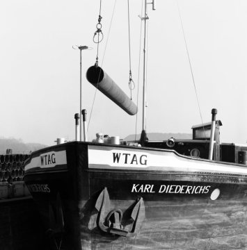 Verladung von Stahlröhren eines Röhrenwerks in Herne [Firmenname unbekannt] auf ein Frachtschiff am Rhein-Herne-Kanal. Februar 1977.